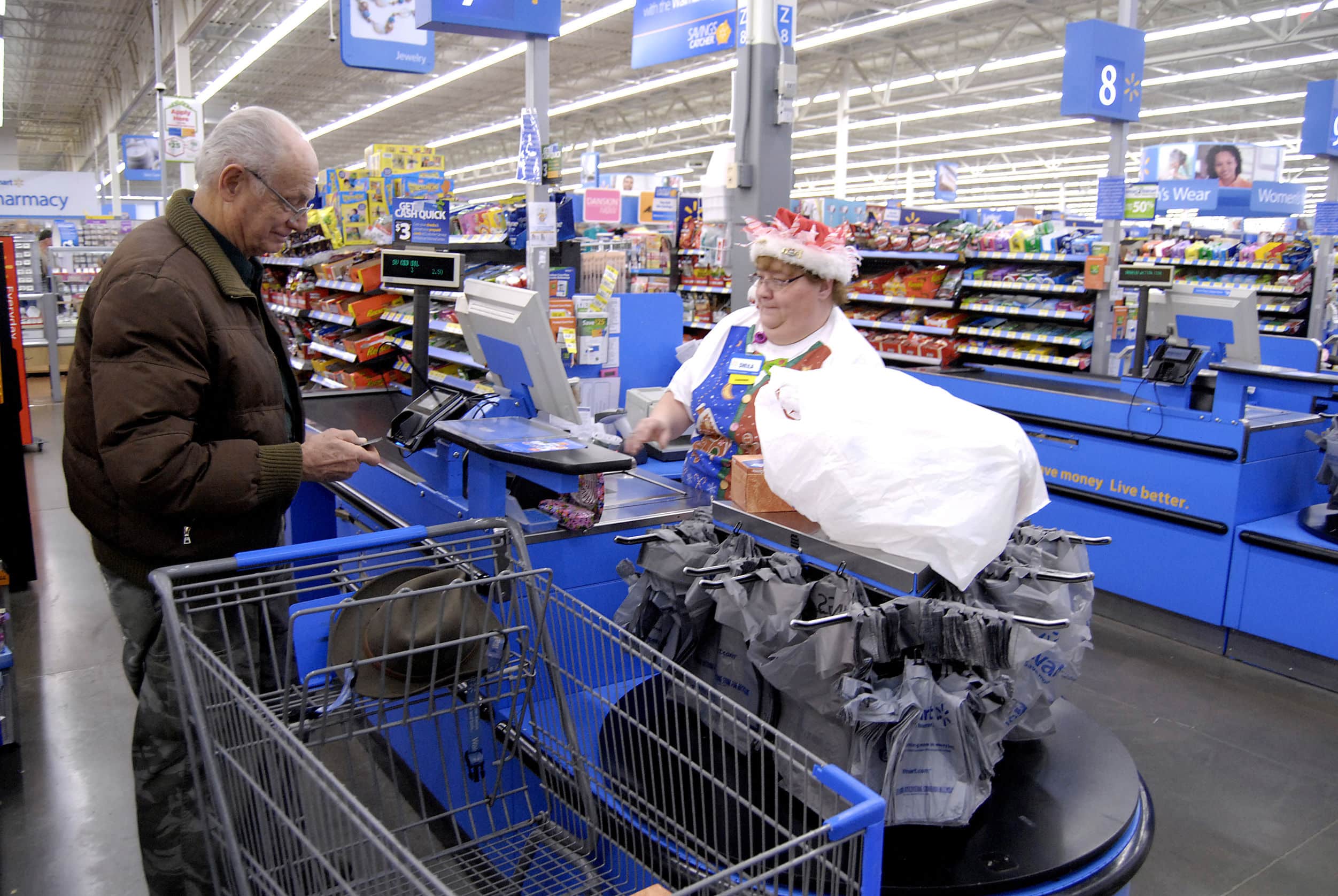 A Walmart employee assisting a customer at the check-out counter